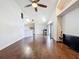 Spacious living room with high ceilings, wood flooring, ceiling fan, and kitchen access at 238 Sunridge Woods Blvd, Davenport, FL 33837