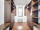 Spacious walk-in closet with custom shelving, drawers, wood floors, and a central mirror for an organized wardrobe at 238 Sunridge Woods Blvd, Davenport, FL 33837