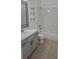 Clean bathroom with gray cabinets, a single sink, and shower-tub combo at 2401 Cedarfield Ln, Kissimmee, FL 34744