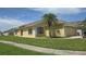 Single-story home with a lush green lawn, shutters, and a two-car garage at 2401 Cedarfield Ln, Kissimmee, FL 34744