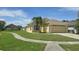 Charming one-story home featuring a well-manicured lawn and an attached two-car garage at 2401 Cedarfield Ln, Kissimmee, FL 34744
