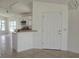 Open-concept kitchen with white cabinets, countertop seating, and modern lighting fixtures at 2401 Cedarfield Ln, Kissimmee, FL 34744