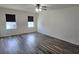 Inviting bedroom showcasing wood-look floors, ceiling fan, and well-lit windows at 2722 Numa Falls Ave, Davenport, FL 33837