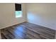 A simple bedroom features wood-style floors and a window, creating a comfortable and minimalist living space at 2722 Numa Falls Ave, Davenport, FL 33837