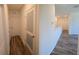 Hallway with wood-style floors leading to multiple rooms, creating a cohesive and stylish transition at 2722 Numa Falls Ave, Davenport, FL 33837