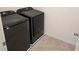 A modern laundry room featuring a brand new, sleek, black washer and dryer set at 2722 Numa Falls Ave, Davenport, FL 33837