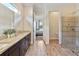Bright bathroom with dual vanities, granite countertops, and a seamless transition to the walk-in shower at 2736 Southland St, St Cloud, FL 34772