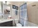 Bright bathroom featuring a granite vanity, brushed metal fixtures, patterned shower curtain and neutral paint at 2736 Southland St, St Cloud, FL 34772