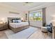 Bright and airy bedroom with a tray ceiling, plush carpet, and large windows showcasing the outdoor view at 2736 Southland St, St Cloud, FL 34772