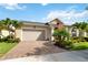 Single Gathering home with a brick driveway, lovely landscaping, and an American flag on the porch at 2736 Southland St, St Cloud, FL 34772