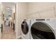 Bright laundry room featuring modern washer and dryer set, granite countertops, and metal shelving at 2736 Southland St, St Cloud, FL 34772