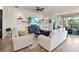 Comfortable living room with a large TV, floating shelves, and a view of the outdoor patio at 2736 Southland St, St Cloud, FL 34772