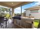 Covered outdoor kitchen with built-in grill, stainless steel appliances, and bar seating at 2736 Southland St, St Cloud, FL 34772
