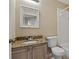 Traditional bathroom featuring a granite countertop, framed mirror, toilet, and a shower with white tiling at 2832 Osprey Cove Pl # 102, Kissimmee, FL 34746