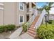 Close-up of condo stairs with white railings and mature landscaping at 2832 Osprey Cove Pl # 102, Kissimmee, FL 34746
