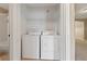 Stacked washer and dryer inside a utility closet with shelving above at 2832 Osprey Cove Pl # 102, Kissimmee, FL 34746