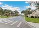 Gated entrance to Osprey Cove featuring mature trees and well-maintained landscaping at 2832 Osprey Cove Pl # 102, Kissimmee, FL 34746