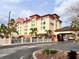 Inviting hotel exterior featuring a porte cochere, manicured landscaping, and prominent signage at 3000 Maingate Ln # 414, Kissimmee, FL 34747