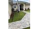 Charming stone walkway leading to the front door with attractive landscaping at 306 Clermont Dr, Kissimmee, FL 34759