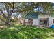 Backyard with partial fence, wood deck, mature trees, and house with sliding glass doors at 3228 Fairfield Dr, Kissimmee, FL 34743