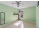 This light green bedroom has a ceiling fan, neutral tile floors, and a floating shelf at 3228 Fairfield Dr, Kissimmee, FL 34743