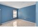 This blue bedroom has neutral tile floors, a window with blinds, and good natural light at 3228 Fairfield Dr, Kissimmee, FL 34743