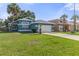 Attractive home features a neatly kept lawn, palm trees, and an attached two-car garage at 3228 Fairfield Dr, Kissimmee, FL 34743