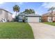 Inviting single-Gathering home showcasing lush green lawn, and a two car garage at 3228 Fairfield Dr, Kissimmee, FL 34743