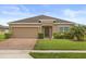 Charming single-story home with a well-manicured lawn, a brick driveway, and a two-car garage at 3797 Briarwood Estates Cir, St Cloud, FL 34772