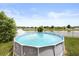 Backyard featuring an above ground pool surrounded by well-maintained landscaping and white fencing at 3797 Briarwood Estates Cir, St Cloud, FL 34772