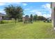 Expansive backyard with a playground and a well-maintained lawn, enclosed by a black fence at 3853 Cortland Dr, Davenport, FL 33837