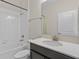 Clean bathroom with a shower-tub combo, white tile, and vanity with a bright white countertop and modern fixtures at 3853 Cortland Dr, Davenport, FL 33837