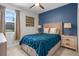 Stylish bedroom featuring a blue accent wall, plush bedding, and well-coordinated decor with great natural light at 3853 Cortland Dr, Davenport, FL 33837