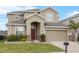 Inviting two-story home boasting a red front door, a two car garage, and well-kept landscaping at 3853 Cortland Dr, Davenport, FL 33837
