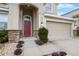 Charming front entrance with a red door, stone accents, and a well-manicured landscape at 3853 Cortland Dr, Davenport, FL 33837