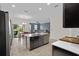 Open floor plan kitchen featuring black cabinets, stainless steel appliances, and tile floors at 3853 Cortland Dr, Davenport, FL 33837