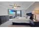 Serene bedroom with fireplace, TV, plush bed, ceiling fan, and a scenic view from the window at 3853 Cortland Dr, Davenport, FL 33837