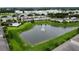 Community aerial view showcasing a pond with fountain, green spaces, and residential buildings at 403 Arbor Lakes Dr, Davenport, FL 33896
