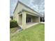 Covered back patio features a concrete floor and light yellow siding, creating a comfortable outdoor space at 403 Arbor Lakes Dr, Davenport, FL 33896