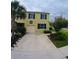 Charming two-story home with a large concrete driveway, green lawn, and carefully planted landscaping at 403 Arbor Lakes Dr, Davenport, FL 33896