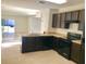 Functional kitchen features dark cabinets, matching appliances, and an adjacent dining area with sliding door access at 403 Arbor Lakes Dr, Davenport, FL 33896