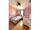 Charming bedroom with whimsical wall decals, a crib, and a comfortable bed on hardwood floors at 4151 Nelson Rd, Lake Wales, FL 33898