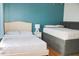 Bright bedroom featuring two beds, a turquoise accent wall and hardwood floors for a welcoming and comfortable space at 4151 Nelson Rd, Lake Wales, FL 33898