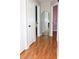 Hallway with wood floors with multiple doorways and a long mirror adding depth to the space at 4151 Nelson Rd, Lake Wales, FL 33898