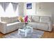 Bright living room with a large white sectional, glass coffee table and hardwood floors at 4151 Nelson Rd, Lake Wales, FL 33898