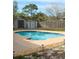 Inviting backyard pool area featuring a unique shape, brick pavers, and convenient shed storage at 4151 Nelson Rd, Lake Wales, FL 33898
