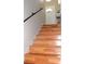 Wooden staircase featuring hardwood floors, a handrail and a view of the front door at 4151 Nelson Rd, Lake Wales, FL 33898