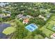 Overhead view features beautiful homes with mature trees, a lake, and a tennis court at 4224 Clarice Estates Dr, Windermere, FL 34786