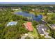 An aerial view of a property with mature landscaping bordering a placid lake at 4224 Clarice Estates Dr, Windermere, FL 34786