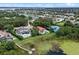 Aerial view of a neighborhood showcasing homes and a terracotta roofed house with pool and tennis court at 4224 Clarice Estates Dr, Windermere, FL 34786